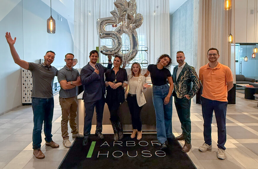 Arbor House is fifty percent leased with team posing in lobby.
